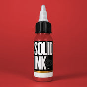 Solid Ink Blood tattoo ink 2 oz bottle on coloured background