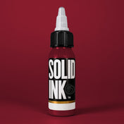 Solid Ink Burgundy tattoo ink 2 oz bottle on coloured background