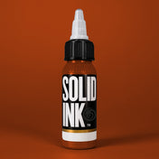 Solid Ink Burnt Orange tattoo ink 2 oz bottle on coloured background