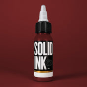 Solid Ink Deep Red tattoo ink 2 oz bottle on coloured background