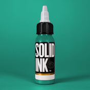 Solid Ink Dragon tattoo ink 2 oz bottle on coloured background