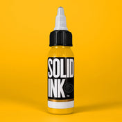 Solid Ink El Dorado Yellow tattoo ink 2 oz bottle on coloured background