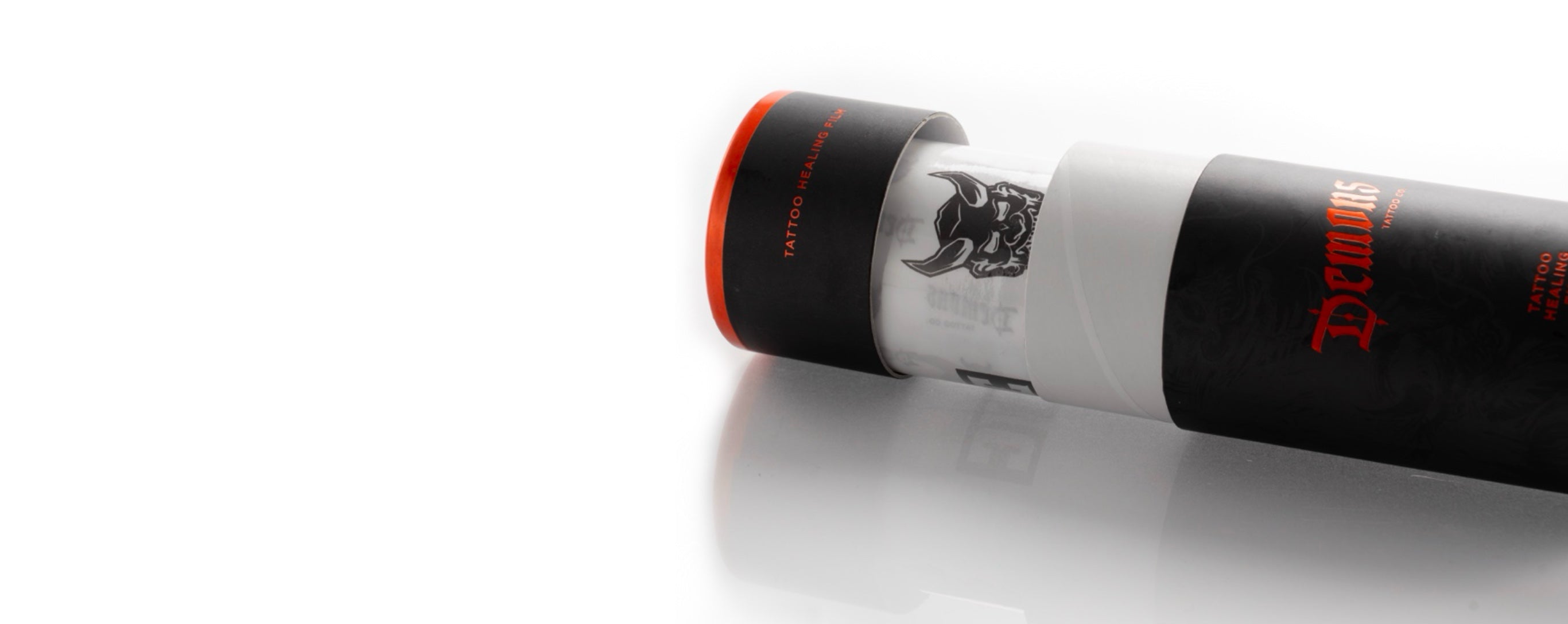 Demons tattoo healing film tube lying on its side, demon head and red lettering