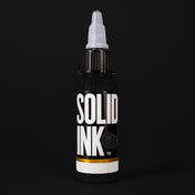 Solid Ink Matte Black tattoo ink 2 oz bottle on black background