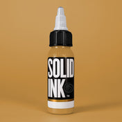 Solid Ink Ochre tattoo ink 2 oz bottle on coloured background