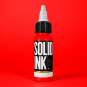Solid Ink Red tattoo ink 2 oz bottle on coloured background