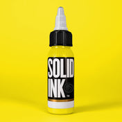 Solid Ink Yellow tattoo ink 2 oz bottle on coloured background