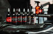 Six Panthera ink bottles set out on a black studio workstation next to a tattoo machine