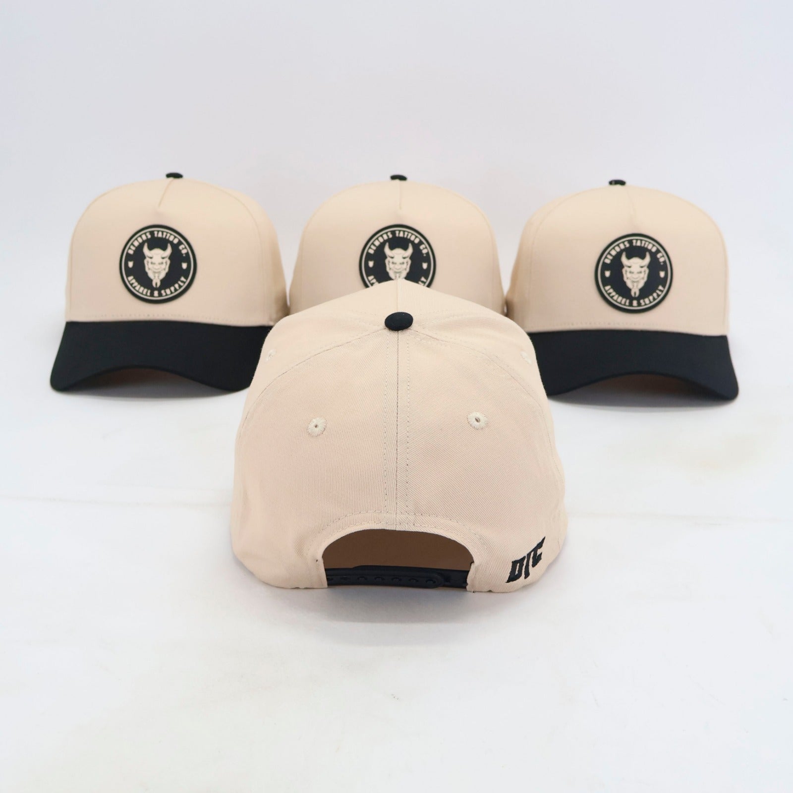 Arrière de la snapback Demons crème avec la fermeture à pression noire et la broderie DTC noire